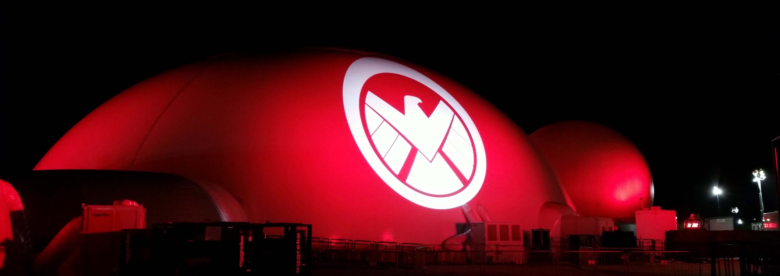 Absolute Hollywood Galactic projection domes with red exterior projection and SHIELD logo displayed on dome surface at night, Marvel Experience worldwide tour 2014 to 2015