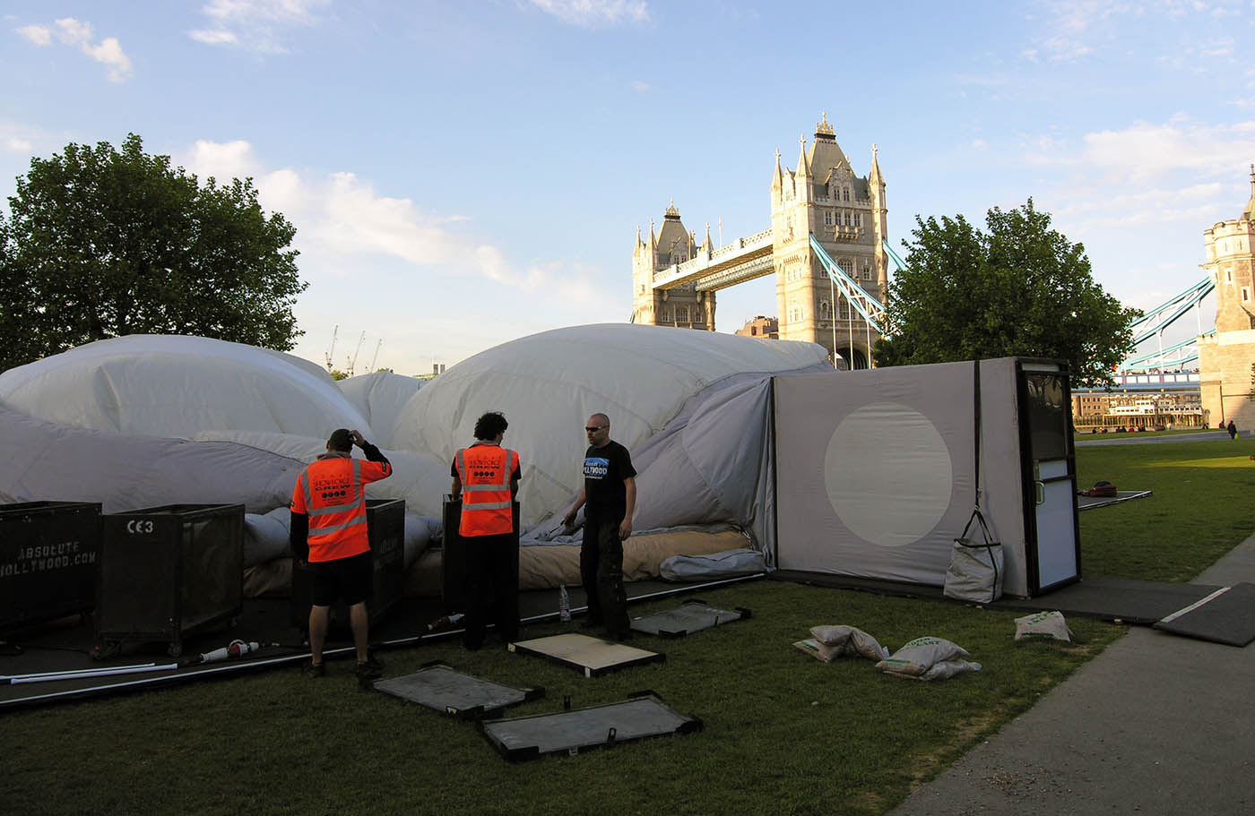 Absolute Hollywood installation crew in branded vests assembling dome entry system near Tower Bridge London, Athens Tour May 2009