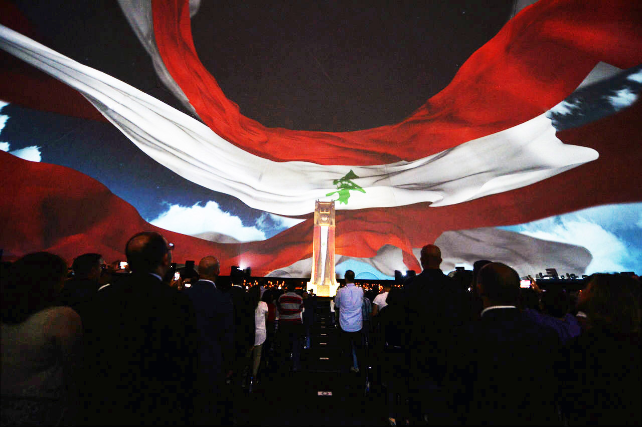 Vast Lebanese flag projected above a seated audience inside the Celestial dome — fulldome immersive cultural program, Beirut