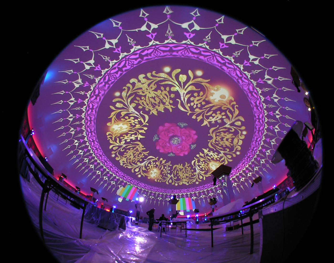 Golden palace-pattern imagery blooming across the dome interior in a fisheye view at full show brightness
