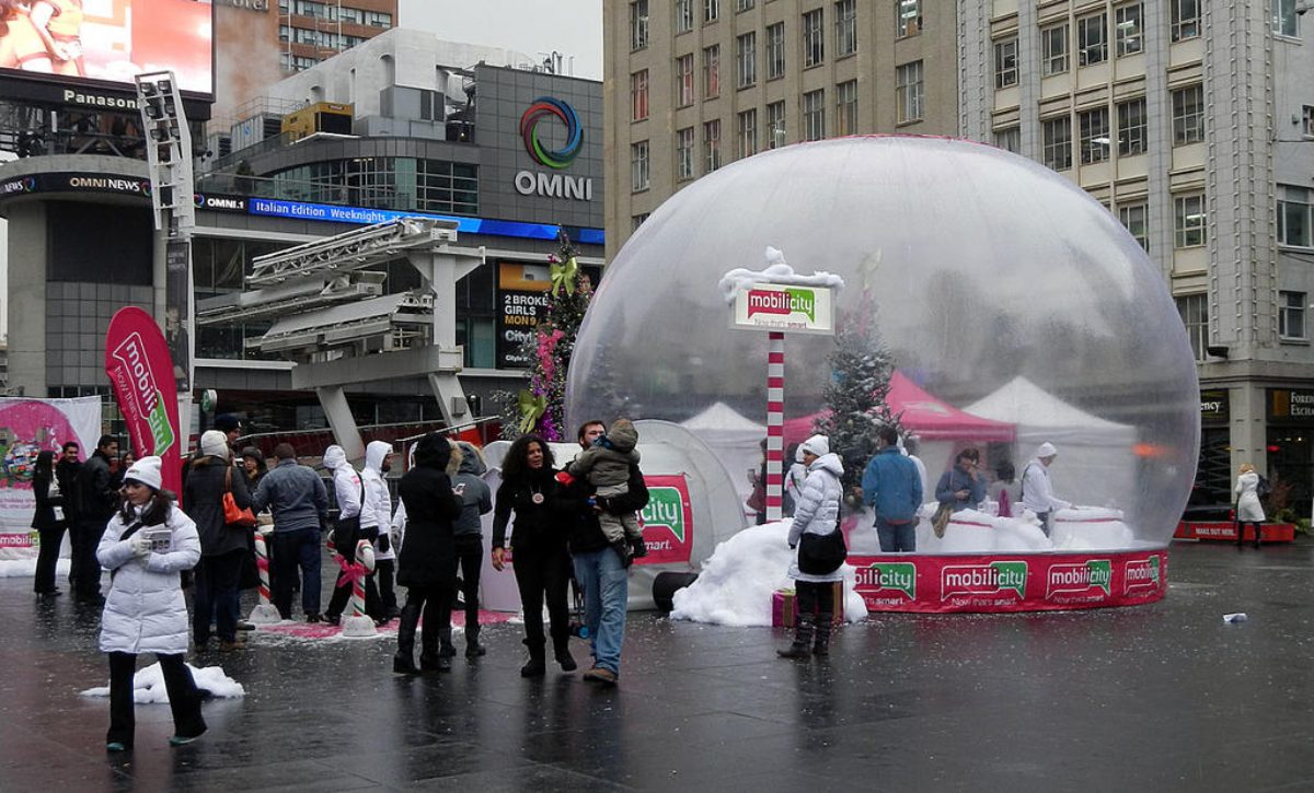 24 ft walk-in inflatable snow globe rental with crowds at Yonge-Dundas Square, Toronto