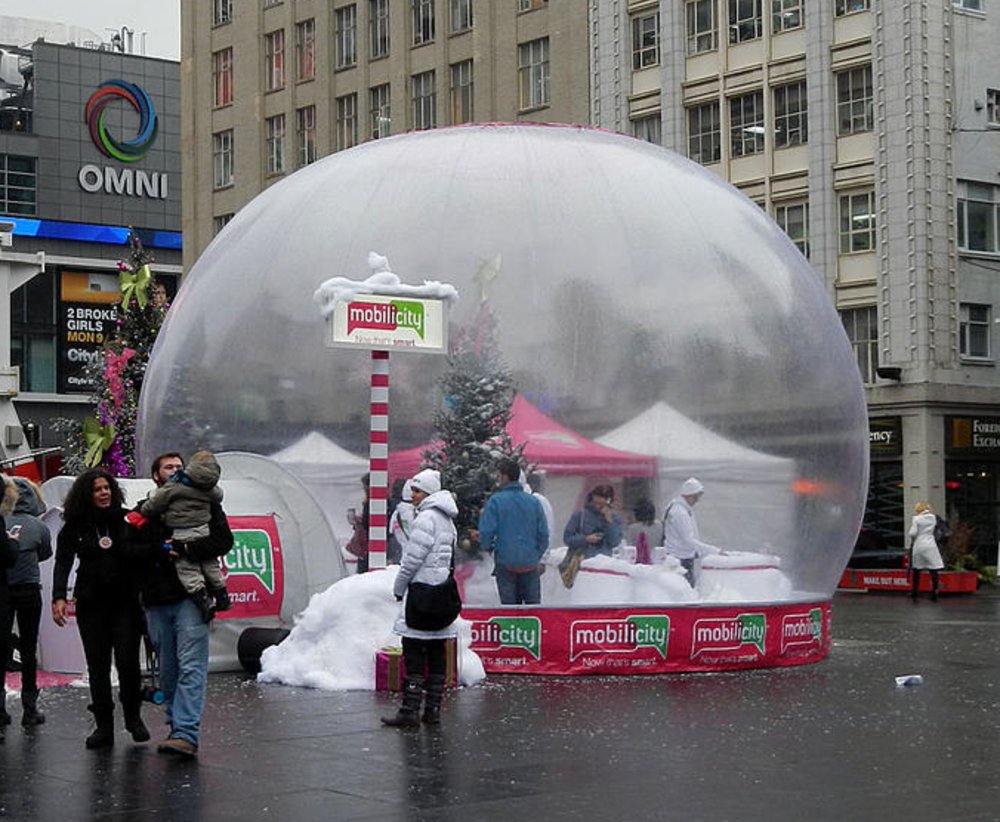 24 ft walk-in inflatable snow globe with Airlock tunnel entry on public display at Yonge-Dundas Square, Toronto