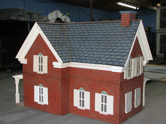 Front elevation of a custom model house built to stand inside a giant snow globe, on the Absolute Hollywood fabrication floor