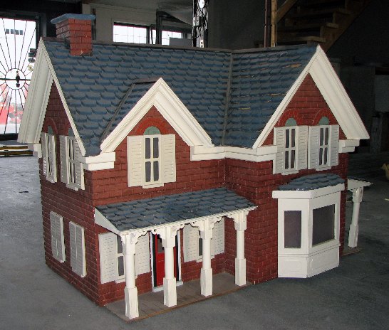 Custom model house with finished porch columns, bay window and chimney, ready for installation inside a giant snow globe