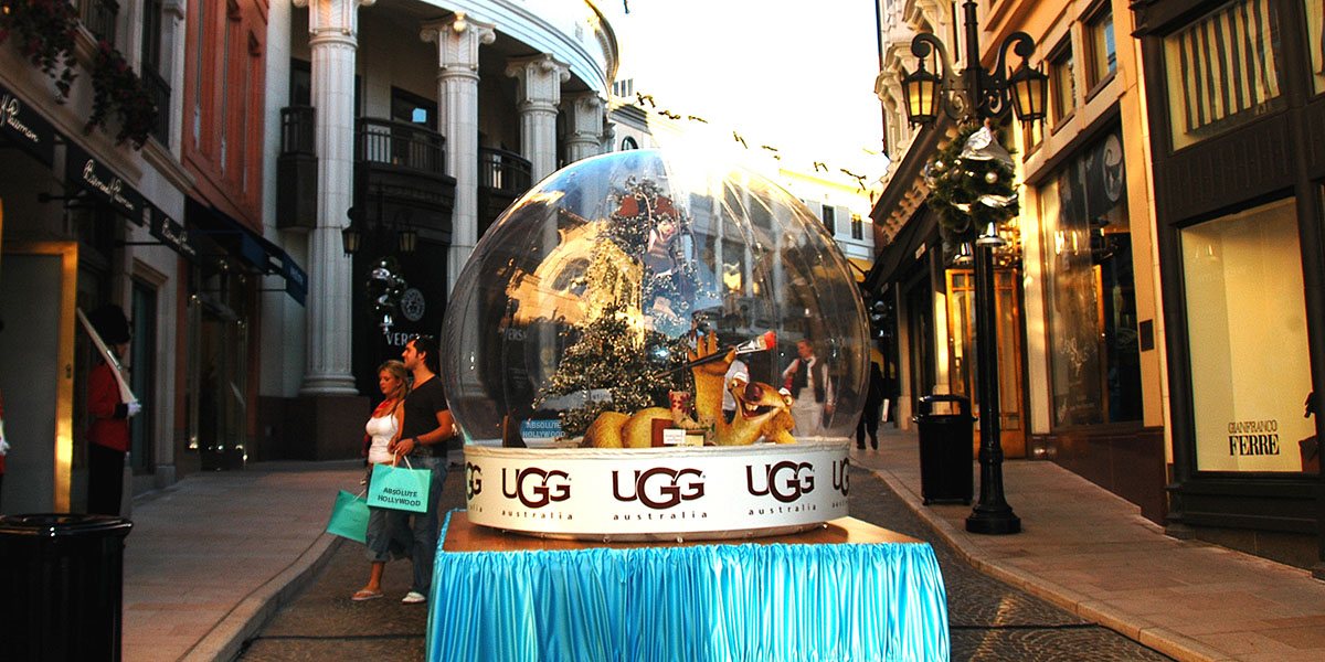 Ice Age The Meltdown Snow Globe — Rodeo Drive Launch Event UGG-branded snow globe rental on Rodeo Drive in Beverly Hills holding a lit Ice Age character scene at dusk