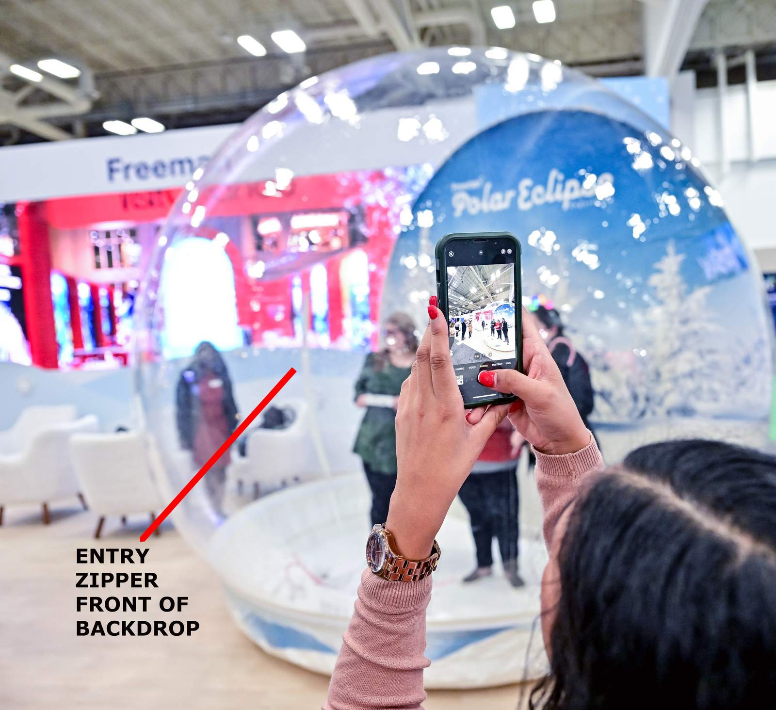 Close view of the full-height entry zipper on a giant snow globe, unzipped for guests and props and re-sealed behind them